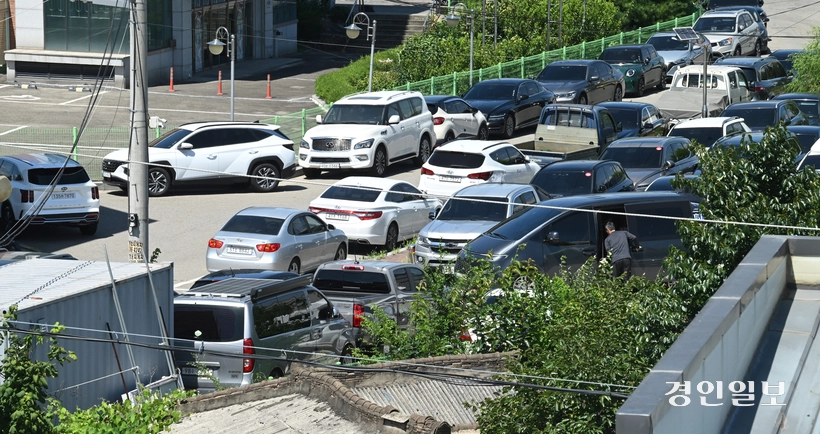 자동차관리법상 매매용 차량은 사업장 내 전시가 원칙이지만, 늘어난 물량 탓에 상당수 중고차 매매상사가 외부 나대지를 임차해 차량을 보관하는 실정이다. 사진은 30일 수원시내 한 중고차단지 인근 부지에 차량이 주차돼 있는 모습. 2026.7.30 /최은성기자 ces7198@kyeongin.com