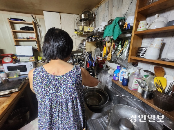 31일 과천시 꿀벌마을 비닐하우스에 거주하는 장모(67)씨가 무더위로 뜨거운 물이 나온다며 물을 틀고 있다. 장씨 역시 에어컨 없이 생활한다. 2026.7.31 /김형욱기자 uk@kyeongin.com