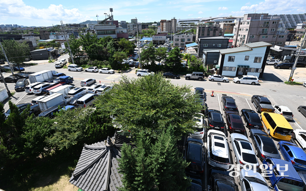 수원시 평동·고색동 일대가 인근 중고차매매단지의 영향으로 자동차 관련 업종이 밀집해 중고차와 상품용 차량이 주차장을 점유하고 있다. 사진은 지난 29일 수원시 평동행정복지센터 일대 도로변에 중고차가 불법주정차돼 있는 모습과 카센터 옆에 상품용 차량이 세워져 있는 모습. 2026.7.29 /최은성기자 ces7198@kyeongin.com