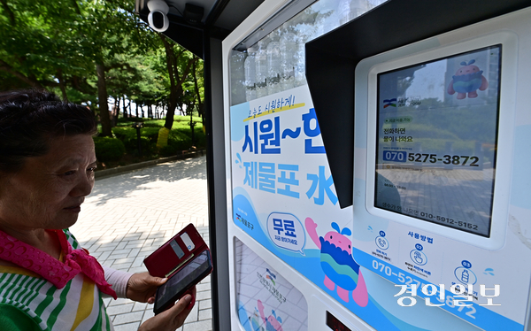 5일 오전 인천시 제물포구 화도진공원에서 한 어르신이 생수 자판기를 이용하기 위해 ARS 본인 인증을 하고 있다. 2026.8.5 /조재현기자 jhc@kyeongin.com