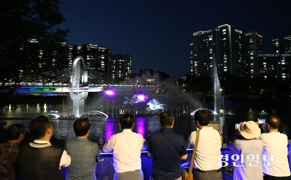 지난 7일 오후 8시께 이현재(왼쪽에서 네 번째) 하남시장과 위례신도시 주민대표들이 위례호수공원 전망대 데크에서 시범 운영되는 워터스크린을 관람하고 있다. 위례호수공원 워터스크린은 오는 13일부터 정식 운영될 예정이다. 2026.8.7 하남/문성호기자 moon23@kyeongin.com