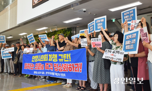 5일 오전 안양시의회 1층 로비에서 개최한 평촌 샘마을 및 관양동 재개발지구 주민들의 ‘안양시의회 정상화 촉구 주민 궐기대회’에서 주민들이 시의회 정상화를 요구하는 현수막과 피켓을 들고 구호를 외치고 있다. 2026.8.5 안양/박상일기자 metro@kyeongin.com