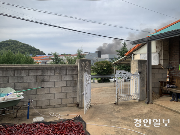 11일 오전 평택시 청북읍 토진리 주민 정모씨의 자택에서 바라본 화재 현장. 주택 너머 위험물 저장시설에서 검은 연기가 피어오르고 있다. 2026.8.11 /유혜연기자 pi@kyeongin.com