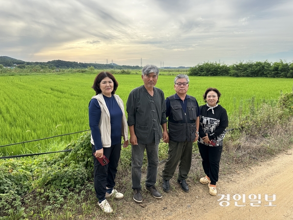 황문식 안산시농민회 회장(왼쪽 두 번째) 등 농민회 회원들이 직접 농사를 짓고 있는 안산시 대부동 시화지구(간척지)의 논 앞에 서 있다. 2026.8.10 /목은수기자 wood@kyeongin.com