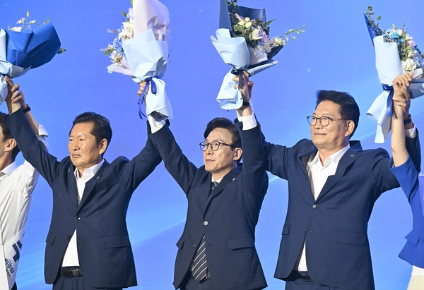 더불어민주당 김민석 신임 당 대표가 17일 대전 컨벤션센터에서 열린 제3회 더불어민주당 정기 전국당원대회에서 당 대표로 선출된 뒤 정청래(왼쪽), 송영길 후보와 함께 당원들에게 인사하고 있다. 2026.8.17 /공동취재