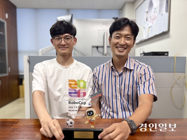 ‘로보컵 2026’ SML 부문에서 우승한 인천대 ‘TEAM INU’를 총괄 지도한 박기원(오른쪽) 바이오로봇시스템공학과 교수와 팀 대표 학생인 박동식(바이오로봇시스템공학과 석사 과정) 씨가 ‘우승 상패’를 보이고 있다. 2026.7.13 /박경호기자 pkhh@kyeongin.com