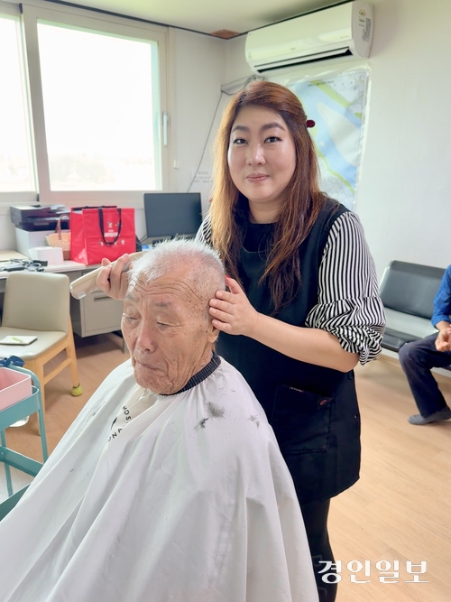 여주 세종대왕면 백석1리 마을회관에서 박은정 원장이 지난 22일 한 어르신의 머리를 깎고 있다. 박 원장은 6년째 매달 셋째 주 토요일 이 자리를 지키고 있다. 2026.8.22 여주/양동민기자 coa007@kyeongin.com