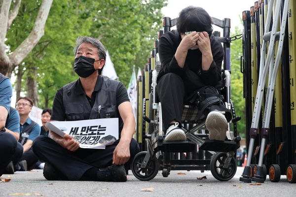 자동차 부품 제조사인 HL만도 경기 평택공장에서 기계 끼임으로 사망한 청년 노동자 고 김승모 씨의 부모님이 21일 청와대 인근에서 열린 ‘만도 평택공장 비정규직 고 김승모 추모제’에서 눈물을 보이고 있다. 2026.8.21 /연합뉴스