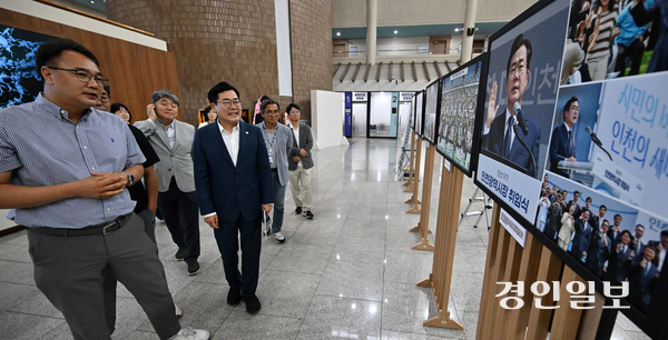 박찬대 인천시장이 27일 시청 중앙홀에서 열린 한국사진기자협회 인천지부 보도 사진전 ‘새로운경계, 새로운 기록’에서 작품들을 관람하고 있다.2026.8.27 /조재현기자 jhc@kyeongin.com