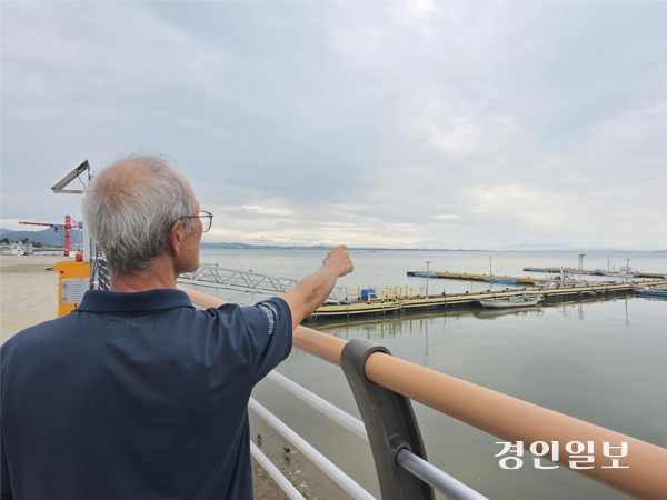 28일 오후 평택 권관항에서 ‘평택·당진항 항만구역 일부 해제 대책위원회’ 사무국장을 맡고 있는 이모(66)씨가 항만구역 해제를 요구하는 지역을 손으로 가리키고 있다. 2026.8.28 /김형욱기자 uk@kyeongin.com