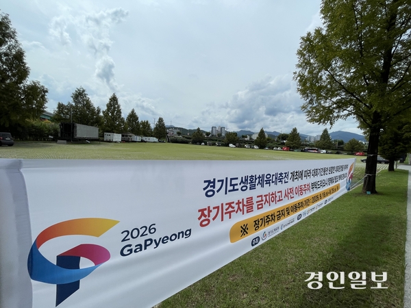 지난 27일 가평군 자라섬 캠핑장 입구 P1 주차장에 이동 야외무대·화장실, 폐 카라반 등 시설물과 카라반, 모터보트, 버스, 특장차 등 20여 대의 차량이 방치된 가운데 ‘장기 주차 금지’ 등을 안내하는 현수막이 내걸려 있다. 2026.8.27 가평/김민수기자 kms@kyeongin.com