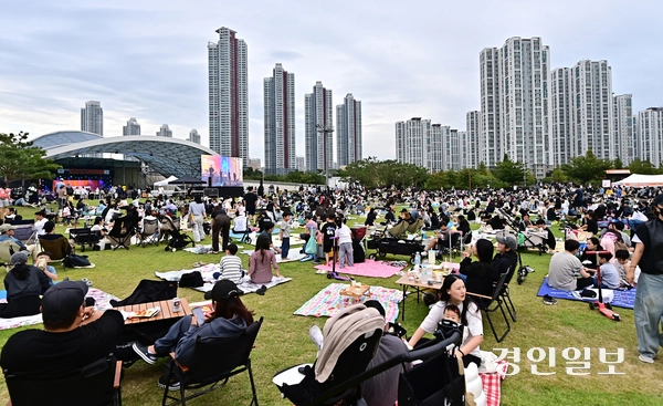 돗자리를 깔고 잔디밭에 자리를 잡은 관람객들이 대형 스크린으로 공연을 보며 성큼 찾아온 가을을 만끽하고 있다. 2026.9.12 /조재현기자 jhc@kyeongin.com