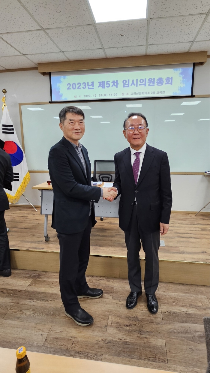 이상헌신임회장(오른쪽) 과 홍응석이임회장이 악수하고 있다.