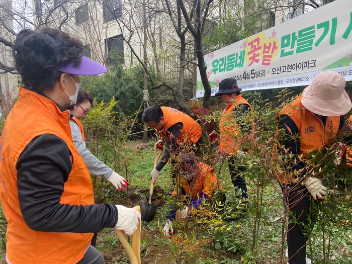 오산신협이 5일 식목일을 맞아 ‘우리동네 꽃밭 만들기 사업’을 진행한 가운데 참여자들이 나무를 심고 있다./오산신협 제공