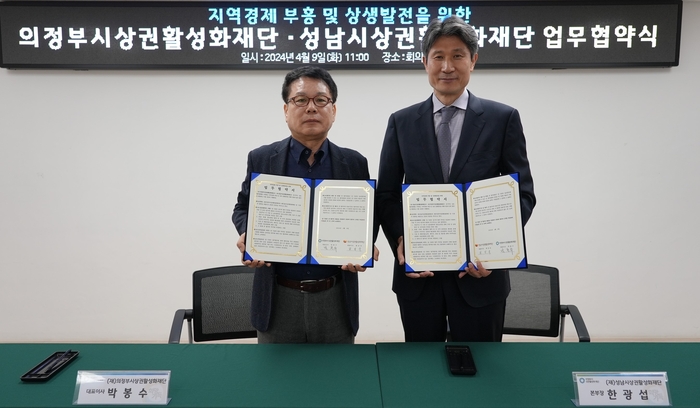 한광섭 성남시상권활성화재단 본부장과 박봉수 의정부시상권활성화재단 대표이사가 협약서를 들어보이고 있다. /성남시상권활성화재단 제공