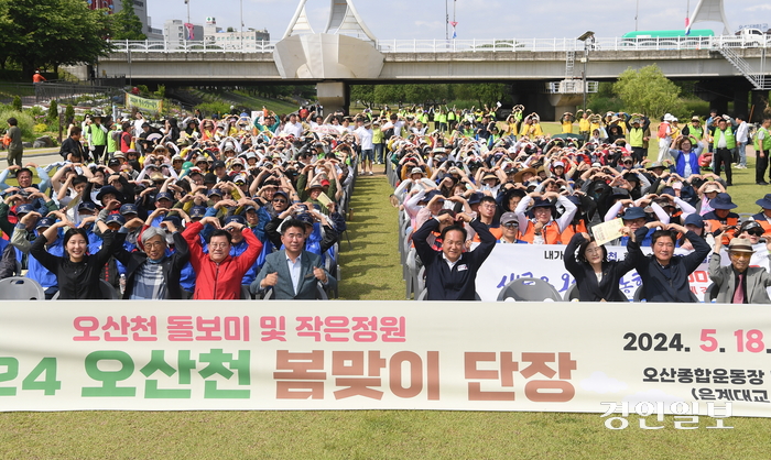 오산천에서 금계국을 심은 뒤 참석자들이 기념촬영을 하고 있다. /오산시제공