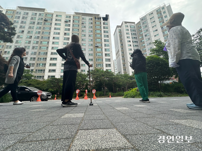 24일 오전 수원시 권선구의 한 아파트에서 불이 난 가운데, 주민들이 화재가 발생한 건물을 바라보고 있다. 2024.5.24 /목은수기자