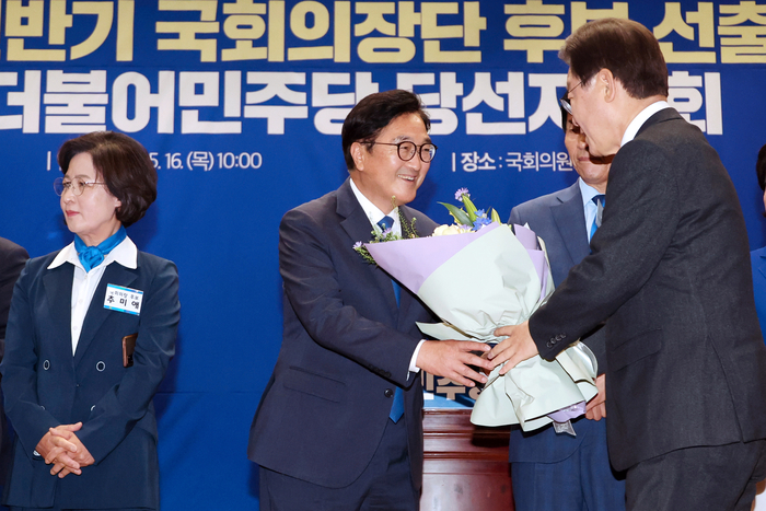 더불어민주당 국회의장 후보로 선출된 우원식 의원이 16일 오전 국회 의원회관에서 열린 제22대 전반기 국회의장단 후보 선출을 위한 당선자 총회에서 이재명 대표로부터 꽃다발을 받고 있다. 2024.5.16 / 연합뉴스