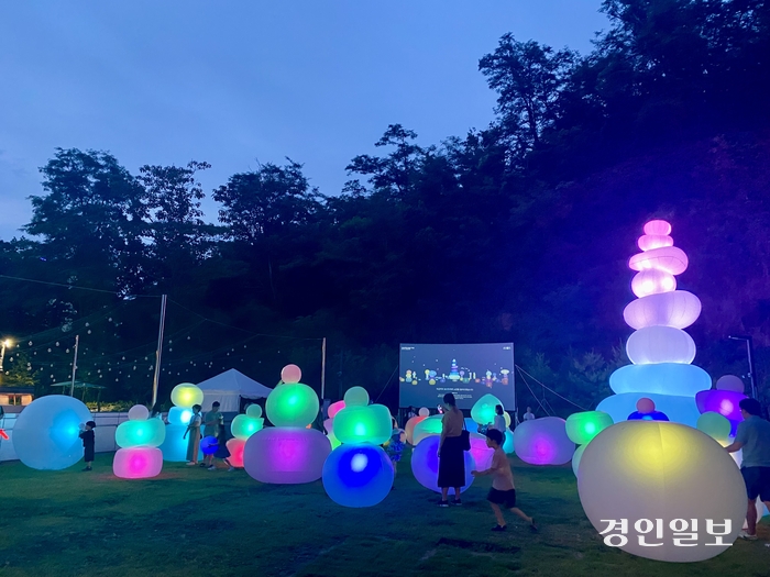 14일 밤 8시 군포시 그림책꿈마루에서 진행된 미디어 아트 ‘오르:빛 워터파고다’에서 체험객들이 ‘물덩어리’로 탑을 쌓고 있다. 2024.6.14 군포/강기정기자 kanggj@kyeongin.com