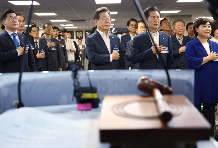 더불어민주당 이재명 대표가 17일 여의도 당사에서 열린 중앙위원회의에서 국기를 향해 경례하고 있다. 민주당은 이 회의에서 대선에 출마하려는 당 대표의 사퇴 시한에 예외를 둘 수 있도록 하는 내용의 당헌 개정을 시도한다. 2024.6.17 /연합뉴스
