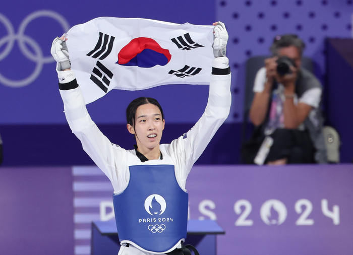 9일(한국시간) 프랑스 파리 그랑팔레 태권도경기장에서 열린 2024 파리 올림픽 태권도 여자 57㎏급 결승전에서 한국의 김유진이 이란의 나히드 키야니찬데를 꺾고 금메달을 확정한 뒤 태극기를 들고 환호하고 있다. 2024.8.9 /연합뉴스