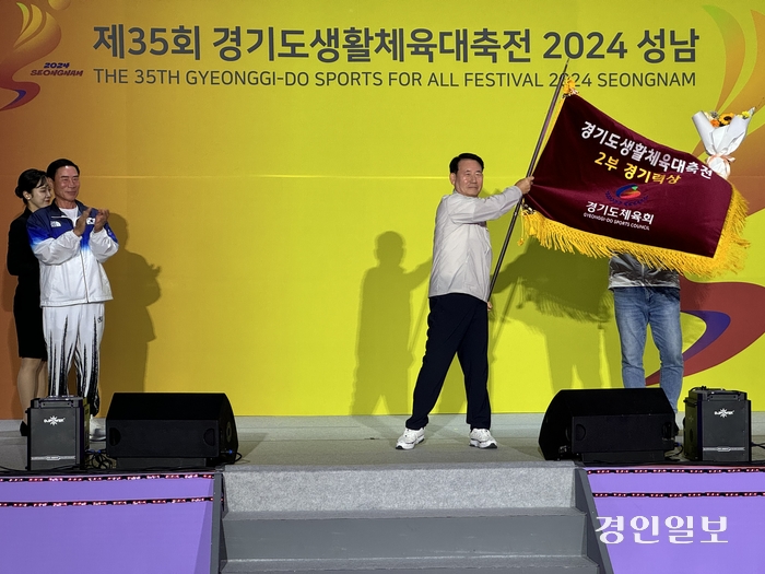 수원시와 오산시가 ‘제35회 경기도생활체육대축전 2024 성남’ 1·2부에서 경기력상을 나란히 수상하며 최고의 건강미를 발산했다. 권병규 오산시체육회장 2부 경기력상을 받은 뒤 흔들고 있다. /경기도체육회 제공
